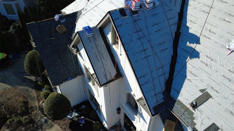 Encompass crew working on a steep front dormer during a roof replacement