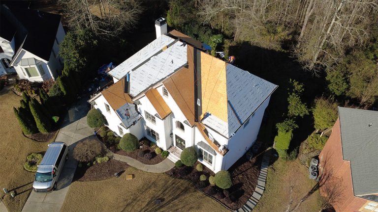 Aerial view of new decking and underlayment on a white stucco home