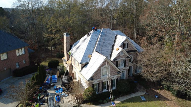 Underlayment going down during a roof replacement on a brick and stone home