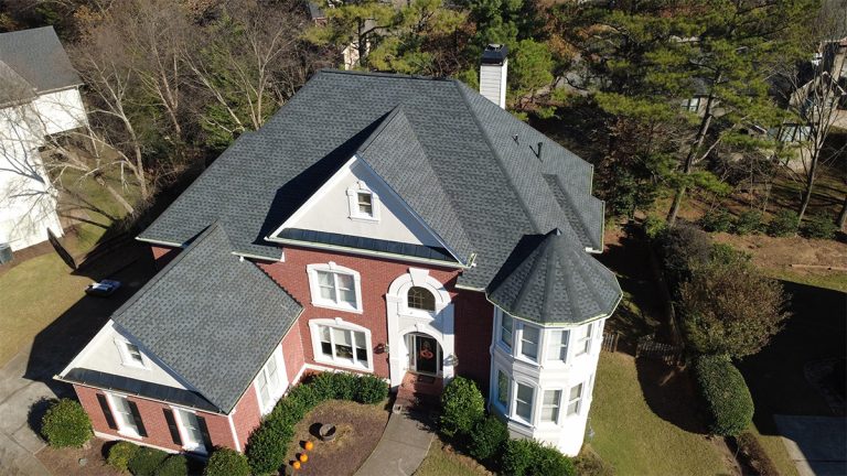 Finished roof replacement on a two-story brick home with a turret